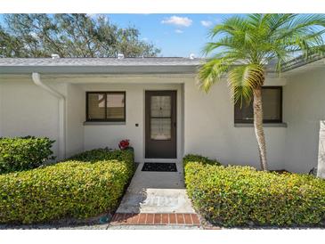 Charming villa front entrance, with lush landscaping, accentuating a welcoming appeal and curb appeal at 2757 Countryside Blvd # 103, Clearwater, FL 33761