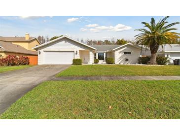 Charming single-story home with a well-manicured lawn, two car garage, and a beautiful palm tree at 4735 Foxshire Cir, Tampa, FL 33624