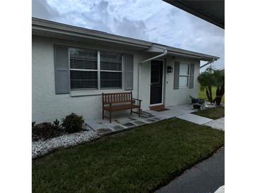 Charming front entrance featuring a cozy bench, well-kept lawn, and decorative stone accents at 2233 Greenhaven Dr # 363, Sun City Center, FL 33573