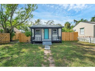 Charming home featuring a cozy front porch and a bright, inviting blue front door at 8308 N Mulberry St, Tampa, FL 33604