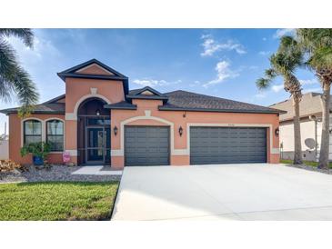 Charming home showcasing a neutral stucco exterior, a 2-car garage, manicured lawn, and inviting curb appeal at 8436 White Poplar Dr, Riverview, FL 33578