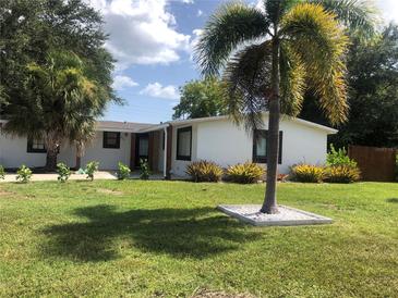 Charming single-story home featuring a well-manicured lawn and lush tropical landscaping in a sunny neighborhood at 907 Fruitland Ave, Bradenton, FL 34207