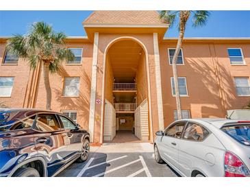 Inviting building entrance featuring covered parking and well-maintained facade with tropical landscaping and sunny skies at 12760 Indian Rocks Rd # 532, Largo, FL 33774