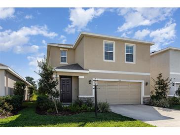 Front view of a two-story home showcasing a tidy lawn and a two-car garage at 3231 Hilltop Cir, Bradenton, FL 34211