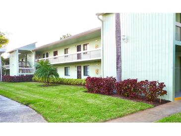 Inviting two-story condo with lush green lawn and colorful landscaping at 128 Nancy Dr # 128, Oldsmar, FL 34677