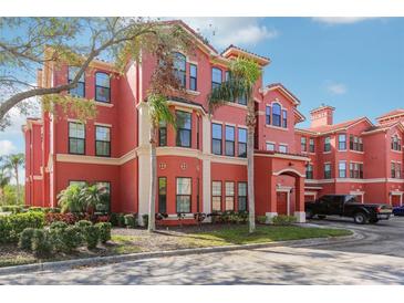 Charming red condo building with well-maintained landscaping and convenient attached garages at 2713 Via Murano # 216, Clearwater, FL 33764