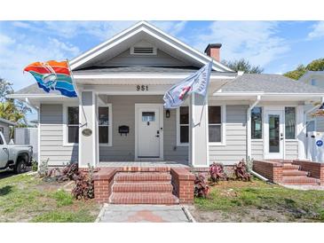 Charming single-Gathering home featuring a well-manicured lawn, brick steps, and a welcoming front porch at 951 9Th S Ave, St Petersburg, FL 33705