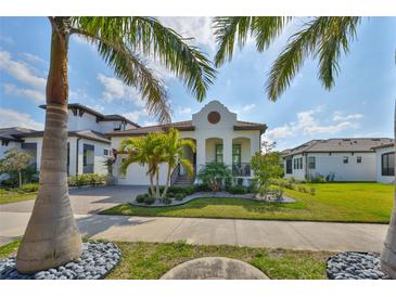 Beautiful home exterior featuring manicured landscaping and a stylish facade under a partly cloudy sky at 1009 Seagrape Dr, Ruskin, FL 33570