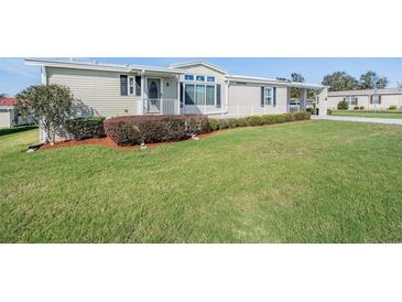 Charming home featuring a well maintained lawn, cozy entryway, and manicured shrubbery at 37508 Gill Ave, Zephyrhills, FL 33541