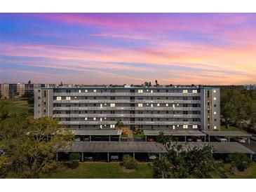 Stunning view of the multi-story condo building featuring covered parking and well-manicured landscaping at 4240 Ironwood Cir # 404, Bradenton, FL 34209