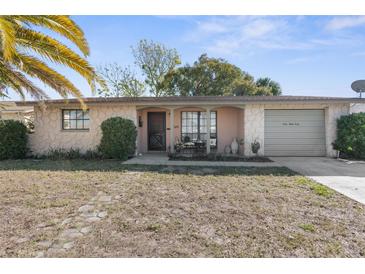 Charming single-story home with a well-manicured front yard and attached garage at 6840 Mesa Verde St, Port Richey, FL 34668