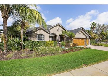 Charming home with well-maintained lawn and tropical landscaping, offering great curb appeal at 2981 Northfield Dr, Tarpon Springs, FL 34688