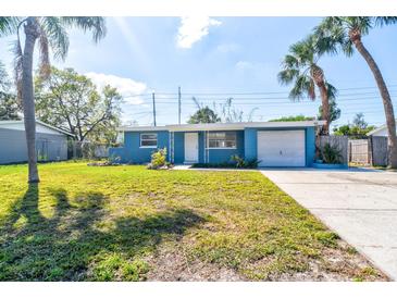 Charming single-story home with blue exterior, manicured lawn, driveway, and lush palm trees at 5600 Bay Ne St, St Petersburg, FL 33703