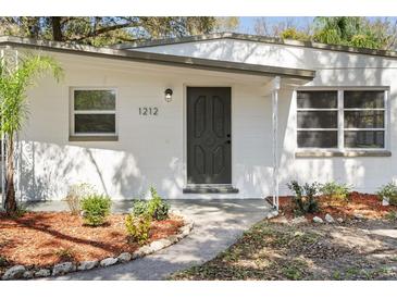 Close-up of front entrance with brick walk way and well-kept landscaped at 1212 E Crawford St, Tampa, FL 33604