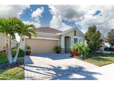 Charming one-story home featuring a two-car garage, a brick paved driveway, and beautifully landscaped yard at 13915 Kingfisher Glen Dr, Lithia, FL 33547