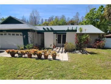 Charming single-story home featuring a landscaped front yard with a pergola-covered entry at 15306 Winterwind Dr, Tampa, FL 33624