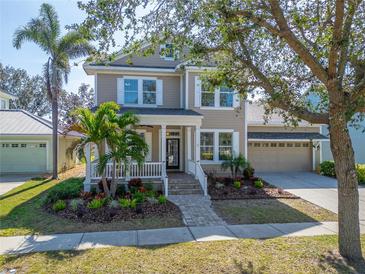 Charming two-story home with well-manicured landscaping and a welcoming front porch at 410 Manns Harbor Dr, Apollo Beach, FL 33572