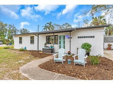 Charming home with a blue front door and two Adirondack chairs on a mulch bed at 4200 Bluefish Se Dr, St Petersburg, FL 33705