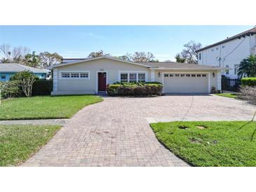 Charming single-story home featuring a brick driveway and a well-manicured front lawn at 547 Suwanee Cir, Tampa, FL 33606
