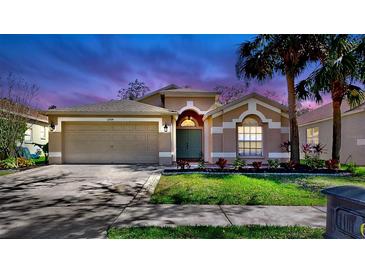 Charming single-story home with a well-manicured lawn and attached two-car garage under a twilight sky at 6004 Martinglade Pl, Lithia, FL 33547