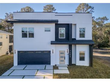 Modern two-story home with a gray garage door and a black and white facade at 7984 Gulf Way, Hudson, FL 34667
