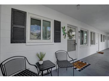 Inviting entrance with chairs and a small table, enhanced by decorative shutters and a charming lizard wall decor at 1546 Pleasant Rd # J1, Bradenton, FL 34207