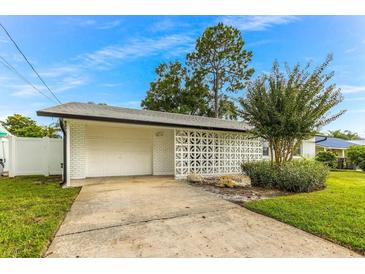 Charming home featuring a white brick exterior, two-car garage, and decorative concrete privacy screen at 8704 Thornwood Ln, Tampa, FL 33615