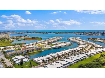 Expansive aerial view of waterfront property featuring a marina, lush landscaping, and stunning ocean views at 1 Boca Ciega Point Blvd # 213, St Petersburg, FL 33708
