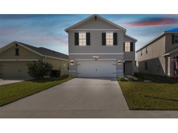 Two-story home boasts a wide driveway and a modern gray facade with black shutter accents at 4727 Lindever Ln, Palmetto, FL 34221