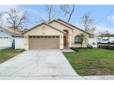 Charming single-story home featuring a well-manicured lawn and an attached two-car garage at 918 W Knollwood St, Tampa, FL 33604