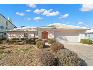 Charming single-story home featuring a white tile roof, front-facing garage, and lovely, low-maintenance landscaping at 10427 Spoonbill W Rd, Bradenton, FL 34209