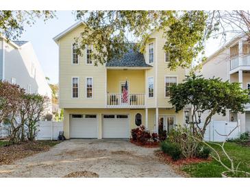 Charming two-story yellow home with a balcony and two-car garage at 476 Rebstock Blvd, Palm Harbor, FL 34683