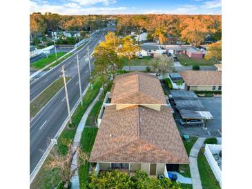 An aerial view showing the exterior of a home with mature landscaping and a nearby road at 7320 Los Padres Ct, Tampa, FL 33634