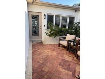 Inviting patio with brick flooring, comfortable seating and lush greenery, perfect for outdoor relaxation at 16103 4Th E St, Redington Beach, FL 33708