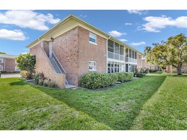 Well-maintained brick condo building with screened in balcony overlooking lush green lawn at 3847 35Th S Way # 108, St Petersburg, FL 33711