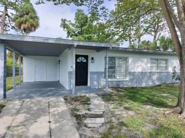 Charming single-story home with a covered carport, black door, and a well-maintained front yard at 6646 Del Prado Ter, New Port Richey, FL 34652