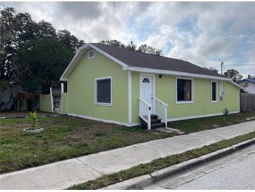 Charming home featuring a white front door, a bright green exterior and neat landscaping at 1554 Tilley Ave, Clearwater, FL 33756