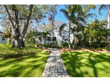 Beautiful home with a stone walkway, mature trees, and well-manicured lawn at 223 33Rd N Ave, St Petersburg, FL 33704