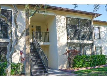 Two-story condo building with stair access to the upper units and well-maintained landscaping at 3367 Crystal E Ct # F, Palm Harbor, FL 34685