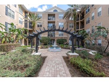 Beautiful courtyard featuring a fountain, lush landscaping, and an elegant pergola at 4221 W Spruce St # 1407, Tampa, FL 33607