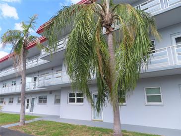 Three-story building with palm trees, balconies, and light blue paint at 5660 80Th N St # A205, St Petersburg, FL 33709