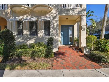 Charming home featuring a brick walkway leading to a blue front door, accented by awnings and lush landscaping at 6030 Printery St # 108, Tampa, FL 33616