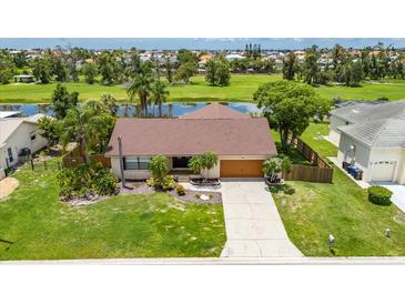 Inviting single-story home featuring lush landscaping, a well-maintained lawn, and a charming front entrance with a 2 car garage at 811 Eagle Ln, Apollo Beach, FL 33572