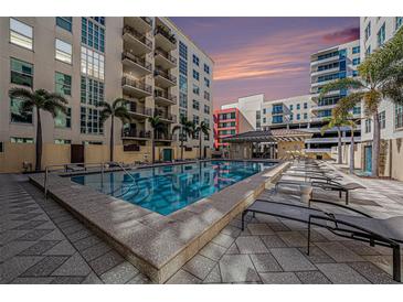 Resort style community pool with lounge chairs, cabana and beautiful tropical landscaping at 1238 E Kennedy Blvd # 704, Tampa, FL 33602