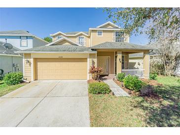 Charming two-story home with a well-manicured lawn, inviting front porch, and attached two car garage at 20326 Merry Oak Ave, Tampa, FL 33647