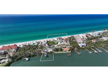 Stunning aerial view of a beachfront home with lush landscaping and private beach access at 2411 And 2407 Casey Key Rd, Nokomis, FL 34275