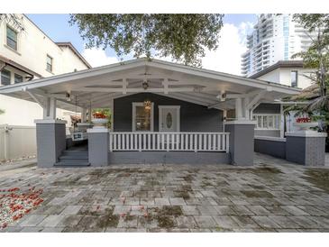 Charming craftsman style bungalow with a spacious front porch and a gray brick driveway at 2921 W El Prado Blvd, Tampa, FL 33629