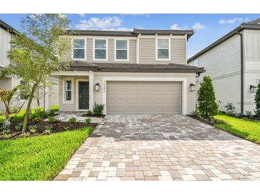 Charming two-story home with a two-car garage, brick paver driveway and manicured landscaping at 10352 Cross River Trl, Parrish, FL 34219