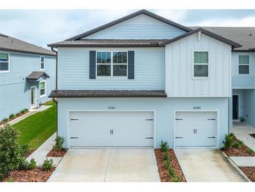 Charming two-story townhome featuring a two-car garage and landscaped front yard at 31381 Amberview Bnd, Wesley Chapel, FL 33545