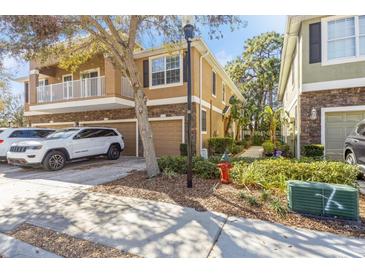 Inviting two-story townhome featuring a balcony, a one-car garage and a beautifully landscaped front yard at 7001 Interbay Blvd # 181, Tampa, FL 33616